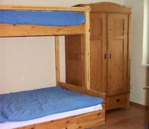 Im Kinderzimmer ist Platz für drei Kids: zwei größere Kleine schlafen im Stockbett, für ein ganz Kleines gibt's ein Gitterbett. 